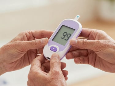 Close-up of senior hands holding a modern digital glucometer, displaying a clear reading under soft warm daylight