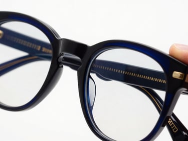 Extreme close-up macro shot of a hand polishing architectural acetate eyewear frame, high-contrast studio lighting, deep navy and gold accents, crisp detail, premium editorial eyewear photography.