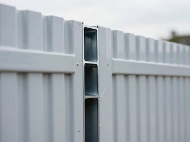 Close-up of a commercial-grade vinyl fence panel, showing internal steel reinforcement ribs through a cross-section detail, sharp focus, crisp daylight, blueprint style.