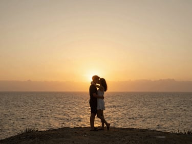 Plano cinematográfico amplio de una pareja abrazada en un acantilado frente al mar al atardecer, luz dorada de contra, siluetas suaves, atmósfera de película de autor.