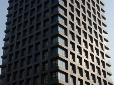 Crisp architectural photography of a modern high-rise exterior in the MENA region, deep charcoal shadows and bright natural light.