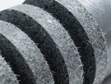 Macro close-up of pre-formed concentric rock wool shells for pipe and circular duct insulation, sharp technical detail