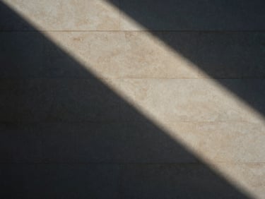 Abstract geometric shadows on a classic limestone wall, soft natural light, sober architectural detail, 35mm