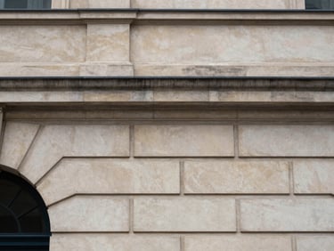 Sober architectural detail of a classic stone facade, soft indirect light, elegant and structured, 35mm