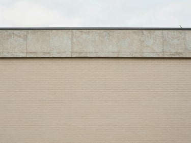 Straight-on architectural detail of clean brick and concrete building facade, soft natural overcast daylight, minimal composition, 35mm lens