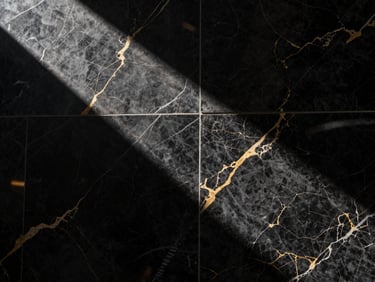 High-contrast commercial lobby featuring UV marble sheets, sharp directional studio light, dramatic shadows, 35mm lens