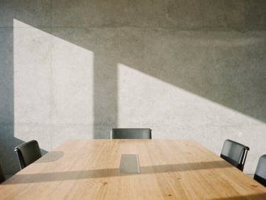 Architectural detail of a clean modern boardroom in Newhall, bright California daylight casting long shadows on a concrete wall, minimal aesthetic, 35mm