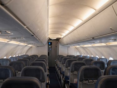 Clean, spacious aircraft cabin with soft, warm lighting, evoking a sense of calm and safety, wide horizontal view