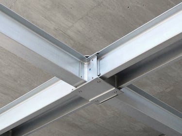 Anodized silver aluminum external cassette mounted on a steel structural beam, sharp architectural photography.