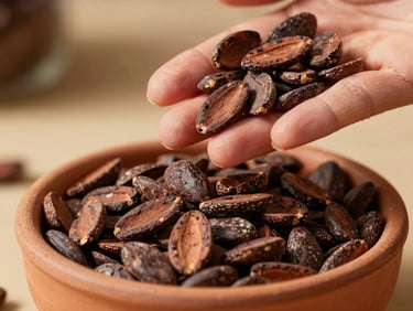 A handful of raw organic cacao nibs being poured into a small terracotta bowl, warm sunlight, macro shot, 35mm