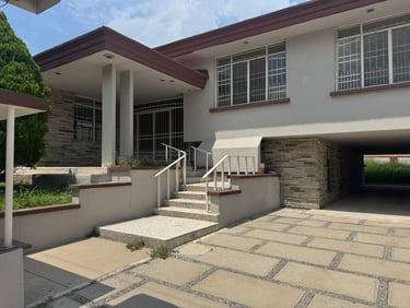 Exterior de una casa de dos pisos de estilo moderno de mediados de siglo con fachada de piedra