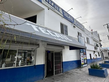 casa con tienda blanca con letreros de Tecate y un toldo gris en una calle en García Nuevo León