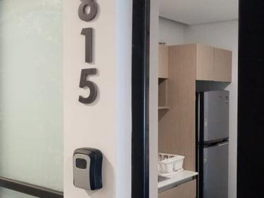 Entrada al apartamento moderno con una caja de seguridad para llaves y vista a una cocineta