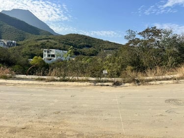 Se vende un solar residencial vacío con vistas a la montaña y lujosas casas modernas