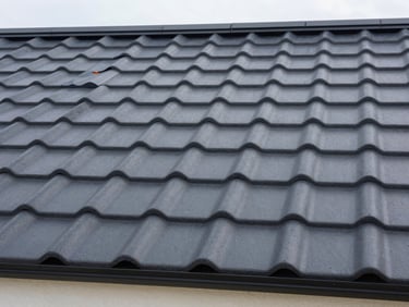 Close-up of premium dark grey metal roofing tiles on a modern cottage, crisp daylight, professional construction photography, 35mm