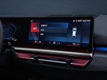 BMW iDrive NBT system main menu on dashboard screen, horizontal tile layout, modern red and blue highlights, dark cabin interior, premium automotive photography, 35mm