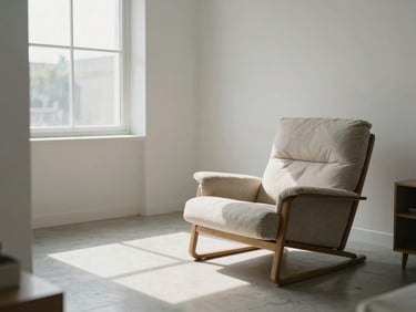 A spacious coliving room with minimalist decor, a comfortable lounge chair, and clean tiled flooring under bright daylight.
