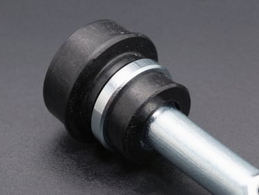 Close-up of clean black rubber suspension bushing sleeves nested in silver steel arms, industrial precision, sharp focus