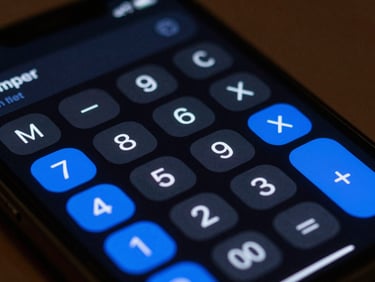 Extreme close-up of a mobile screen displaying a distraction-free calculator interface with monospace typography and vibrant blue active states under low-key studio lighting.