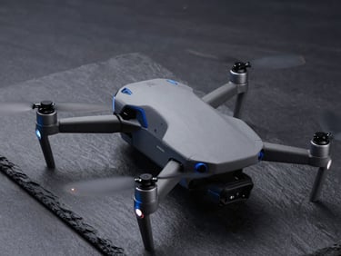 Sleek enterprise quadcopter drone on a dark slate surface, cool blue highlights, sharp focus