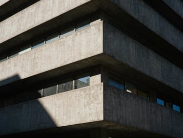 High-contrast architectural details of a brutalist concrete building in Chicago, harsh sunlight casting deep geometric shadows, minimalist composition, 35mm film grain