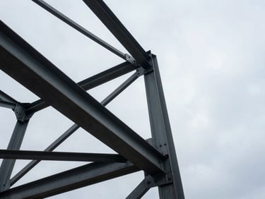 Low-angle heroic shot looking up at a heavy steel structure against an overcast sky, emphasizing structural integrity.