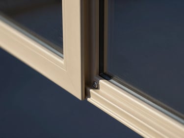 Macro close-up of a sleek champagne-gold aluminium window corner joint, showcasing clean technical lines and precise hardware integration, studio lighting.