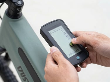 Close-up of hands using a digital diagnostic tool on an e-bike battery pack, sharp focus, technical typography on screen.