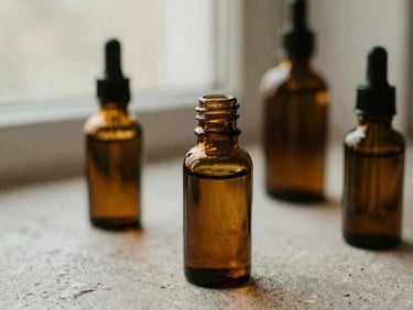 Close-up of botanical massage oils in amber glass bottles on a textured stone surface, soft diffused window light, muted earth tones.