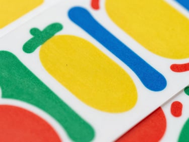 Macro close-up of a sheet of custom die-cut vinyl stickers, showing clean edges and vibrant colors, studio lighting.