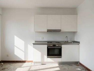 Straight-on architectural photo of scuffed walls, outdated fixtures, and debris in a neglected rental kitchen, harsh shadows.