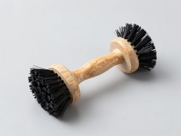 Clean, minimalist cleaning brushes with wooden handles and black bristles, studio shot