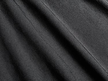 Close-up of heavy-gauge black canvas fabric, showing tight weave and raw texture, under harsh direct daylight, high contrast, 35mm film, sharp focus.
