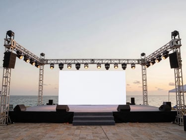 Medium shot of an immaculately set up event stage with professional lighting trusses, ready for a corporate presentation, warm ambient evening lighting, clean composition.