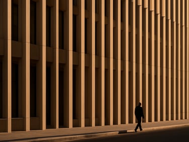 Architectural exterior detail of a Jumeirah residential building facade, late afternoon golden-hour light casting long shadows across concrete fins, street level perspective showing human scale