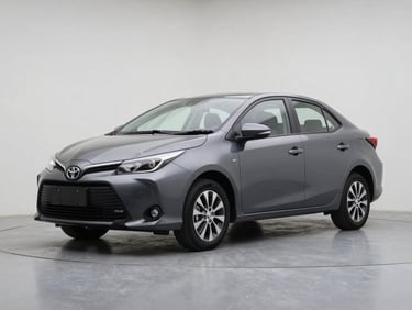 Three-quarter front view of a charcoal grey Toyota Yaris on a clean studio floor, overcast daylight, sharp colour accuracy on body panels and alloy rims