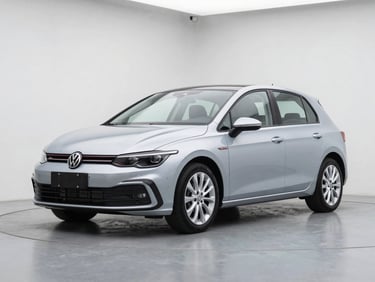 Front three-quarter view of a compact silver hatchback on a clean studio floor, overcast daylight, sharp alloy wheels, no background distractions
