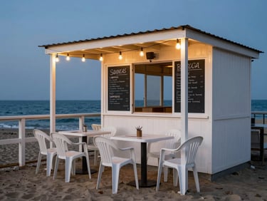 Beach shack restaurant at dusk, simple plastic chairs and a chalkboard menu, string lights overhead, the sea just beyond the railing, no staged props
