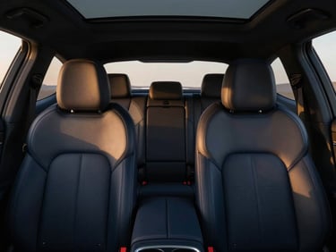 Minimalist interior of a premium car, showing elegant leather seats and clean ambient lighting, quiet luxury atmosphere