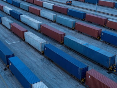 Industrial rail freight terminal with cargo containers, blue hour lighting, sharp focus, professional industrial photography