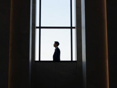 Focused executive in a modern, high-rise office, looking out a window, sharp natural light, architectural framing, off-center