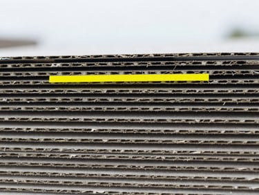 Macro shot of compressed clean cardboard layers, sharp focus, industrial grey tones