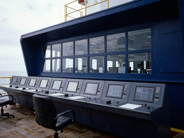 Architectural shot of a modern maritime facility control room, industrial lighting, sharp and authoritative, 35mm.
