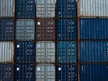 Crisp documentary photography of stacked shipping containers at Apapa port under high-contrast daylight, deep industrial blues, 35mm.