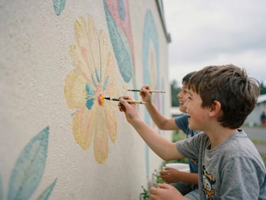 Children laughing while painting a large outdoor mural under an overcast sky, paint-stained hands, candid documentary style.