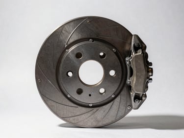 Studio overhead of brake disc and caliper assembly on white surface, part number etched on rotor visible, strong directional shadow