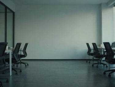 Wide environmental shot of a quiet, empty minimalist office space at dusk, soft diffused green and blue ambient light, 35mm editorial photography.