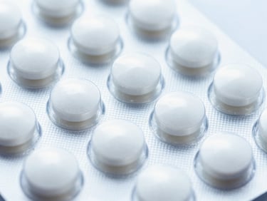 Close-up of pristine blister packs of white pharmaceutical tablets, bright high-key laboratory lighting, sharp macro focus, 35mm
