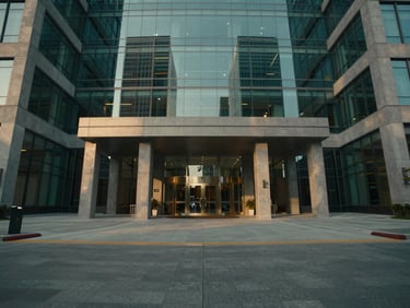 Symmetrical wide-angle shot of a premium corporate office park entrance, sleek concrete and glass architecture, warm low-angle sunlight, 35mm