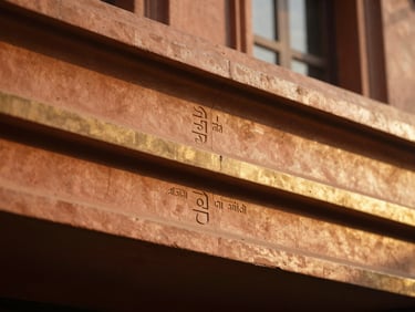 Architectural detail of a building facade with subtle Vastu markings, soft golden light.
